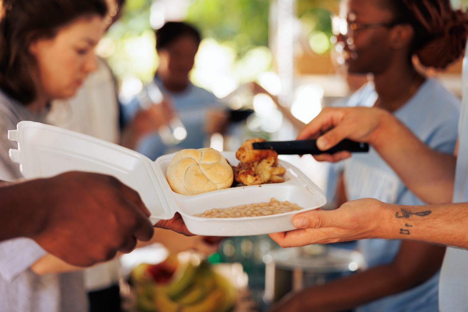 Needy receives meal box from relief team Volunteers with gloves handing out boxes with provisions for donation<br />