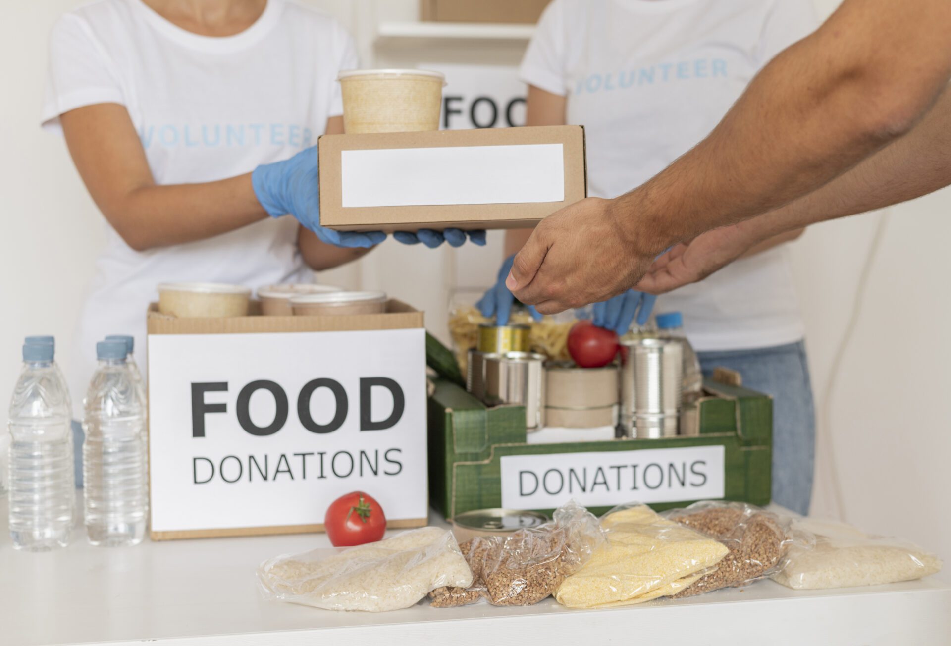 volunteers-with-gloves-handing-out-boxes-with-provisions-donation Volunteers with gloves handing out boxes with provisions for donation